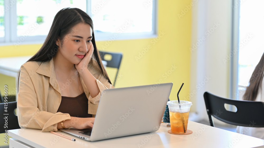 Businesswoman working with laptop on the table in co-working space Businesswoman working with laptop on the table in co-working space