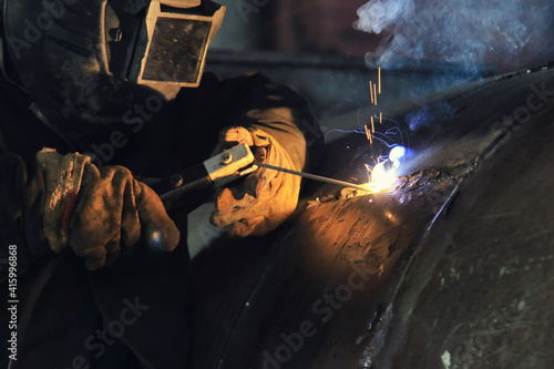 The process of electric arc welding with a melting electrode close-up photo