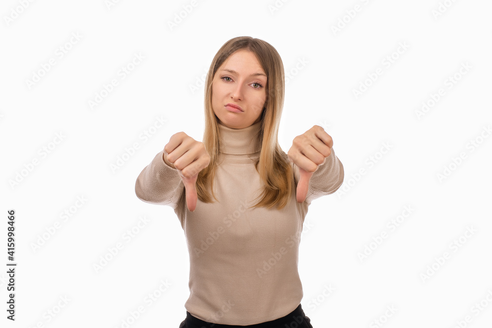 Portrait of attractive blond girl showing thumbs down. Human emotions, gesture concept. Studio shot, white background Portrait of attractive blond girl showing thumbs down. Human emotions, gesture concept. Studio shot, white background