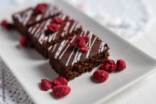 rich dark cocolate brownie cake desert with freeze dried raspsberries 