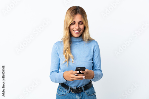 Young blonde Uruguayan woman over isolated background sending a message with the mobile