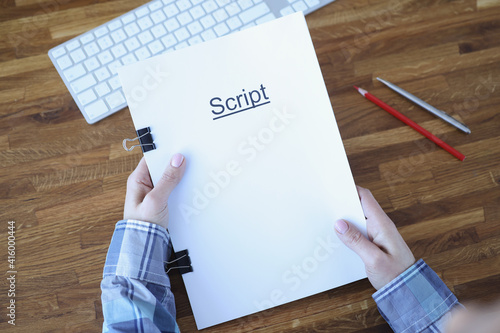 Screenwriter holds folder of documents labeled script photo