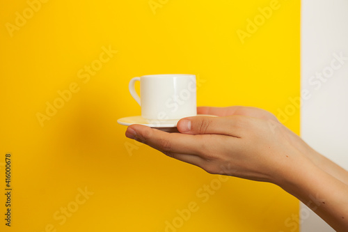 white coffee couple in beautiful female hands on a bright yellow background