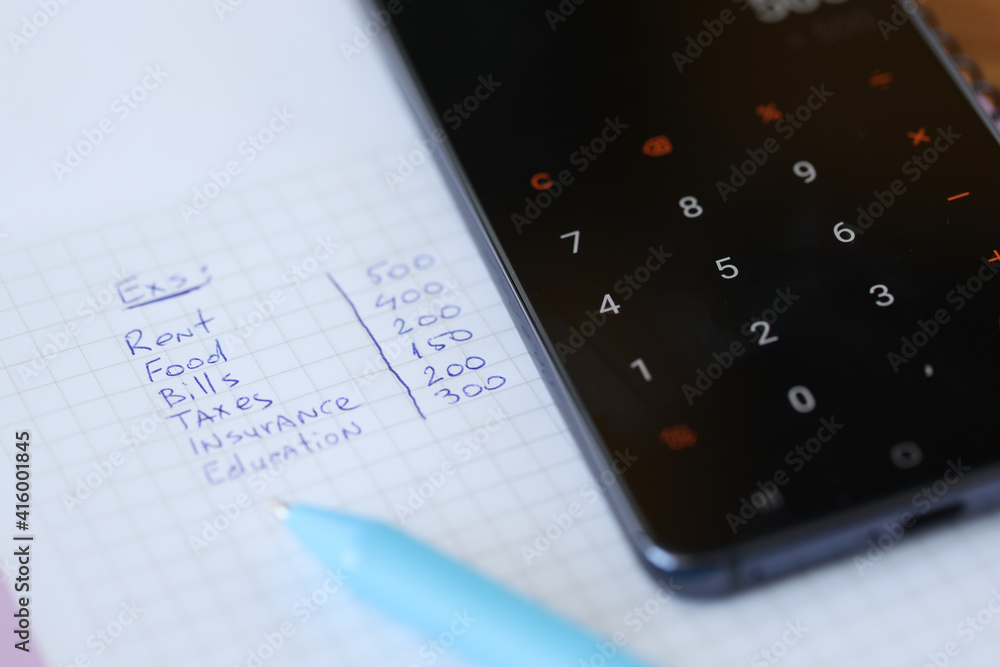 Monthly expenses are written on piece of paper with calculator Monthly expenses are written on piece of paper with calculator