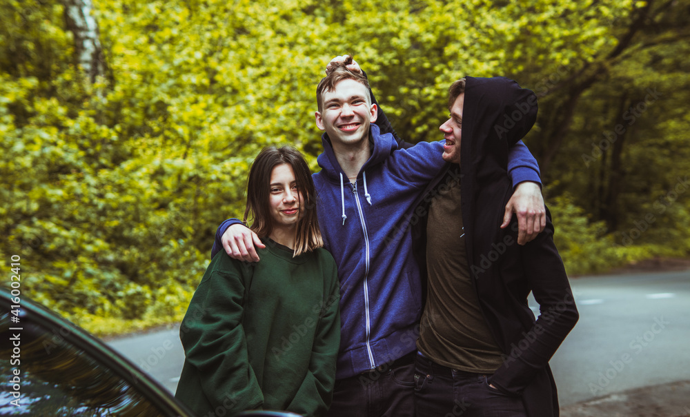 Three friends have fun and make faces on a forest trail between car rides. Three friends have fun and make faces on a forest trail between car rides.