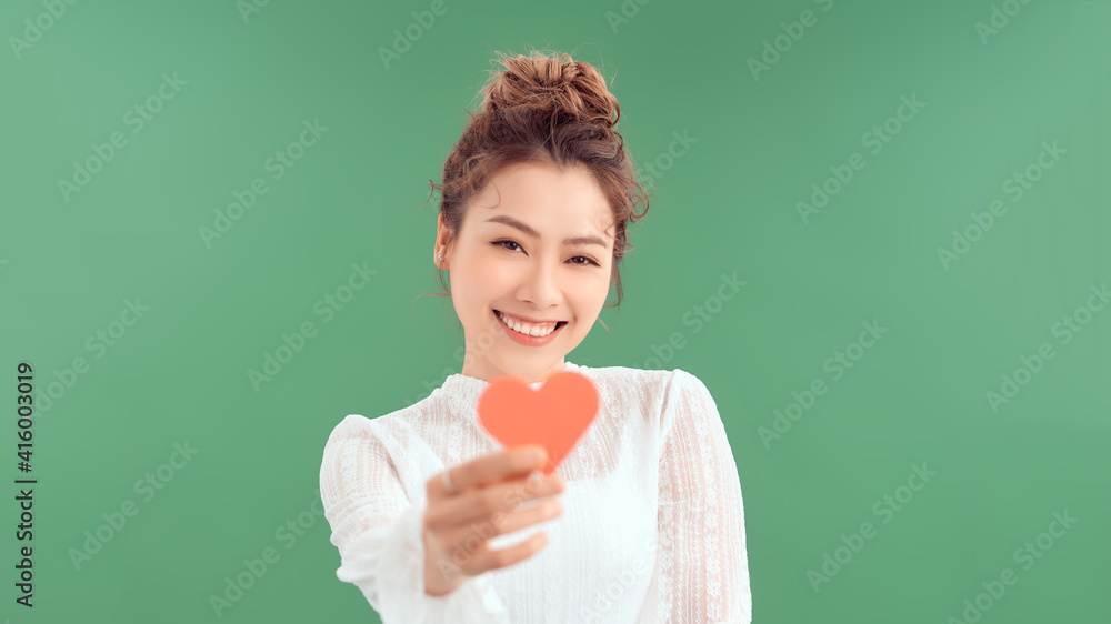 woman holding heart paper valentites card in green background woman holding heart paper valentites card in green background