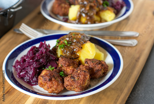 Meatballs with red cabbage, potatoes and onion sauce on a plate