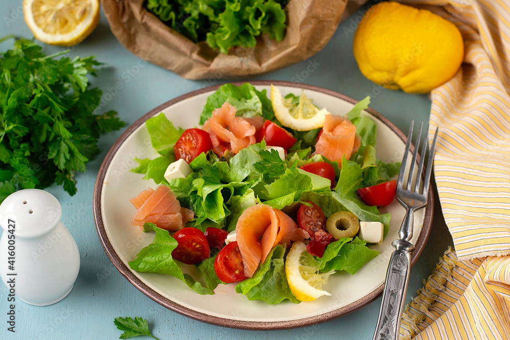 Fresh summer salad with smoked salmon, lettuce, cherry tomato and olives