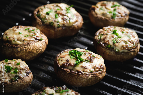 Stuffed mushrooms with cheese and herbs on cooking grate
