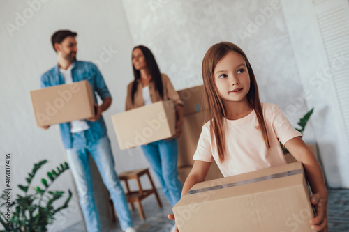 Cute little girl and her parents changing place to live