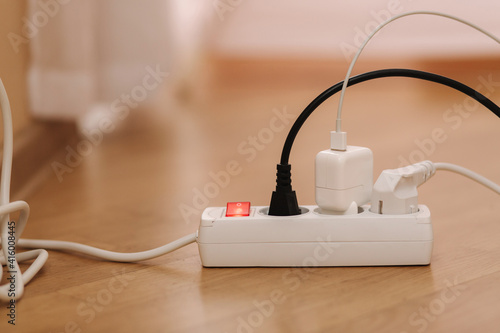 Fotografie White cable connector for overloaded power boards at home
