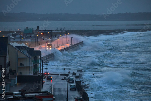 Giant waves and violent storm jumping over the pier in the seaside town of Tramore, Waterford, Ireland. horizontal format