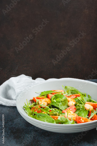 Salad of shrimp prawn and fresh vegetable, leaves of arugula, lettuce.