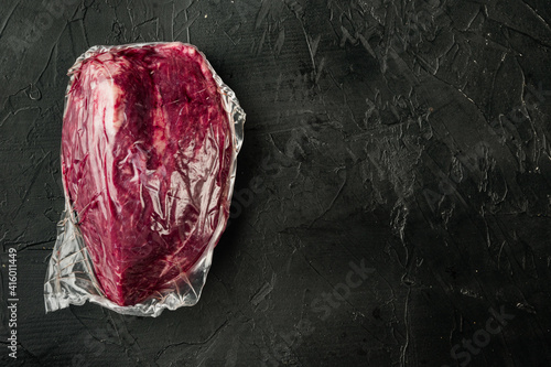 Roast beef in vacuum packed , on black background, top view flat lay, with copy space for text