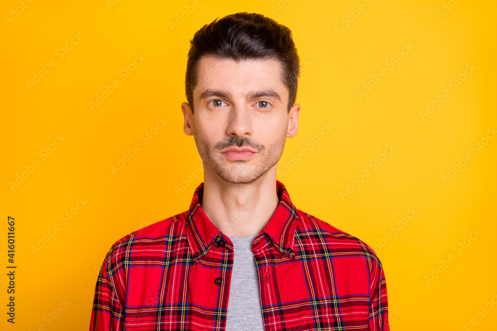 Obraz premium Photo of serious confident young man wear red checkered shirt isolated yellow color background