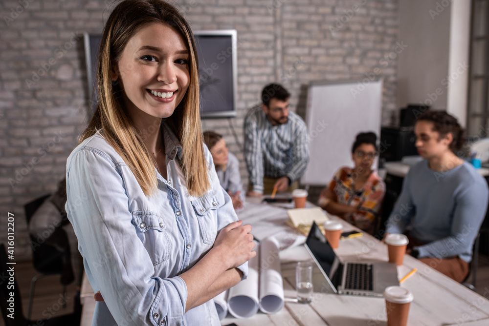 Portrait of young female leader standing in office looking at camera. Portrait of young female leader standing in office looking at camera.