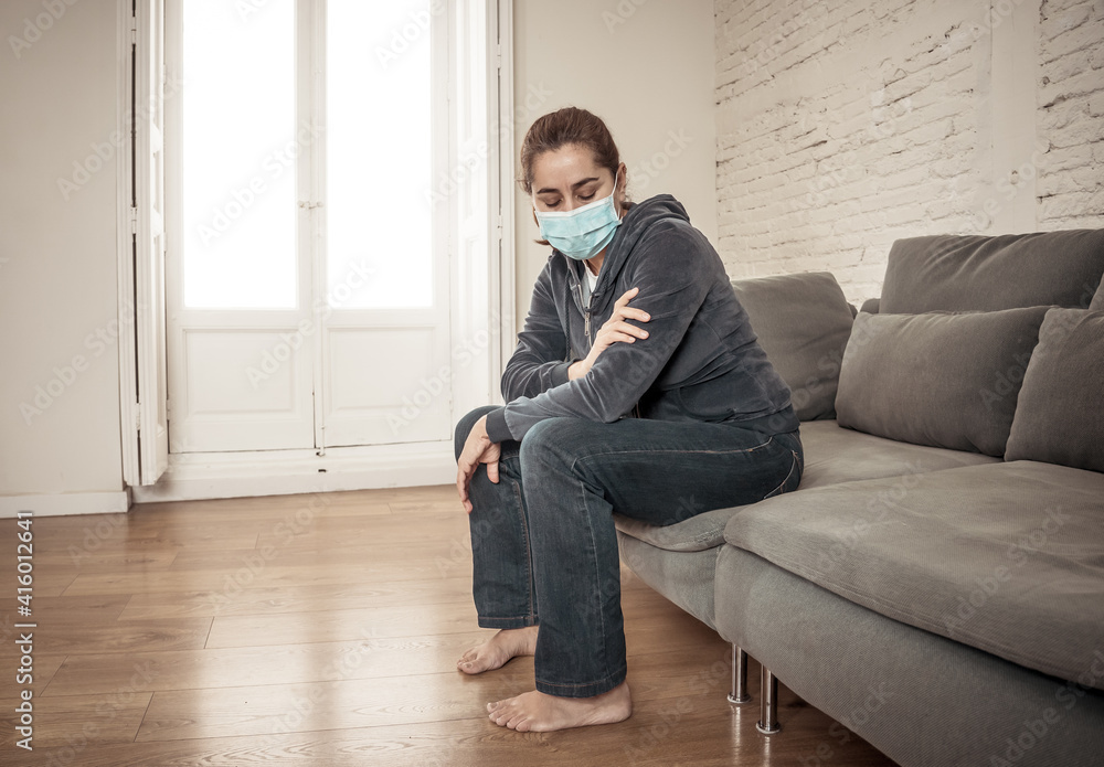 Lonely woman suffering from depression at home during coronavirus lockdown and social distancing