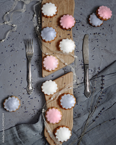 homemade gingerbead cookies glazed in pastel colors sugar icing top view on gray textured background closeup. Selective focus photo