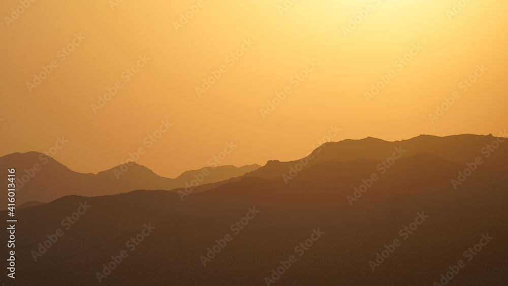 A glowing sunset sky over a mountain range in the Mojave National Preserve