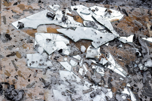 Broken old mirror covered with snow