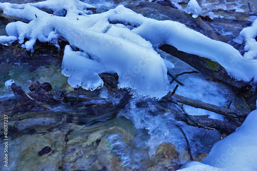 Tauendes Eis im fließenden Bach