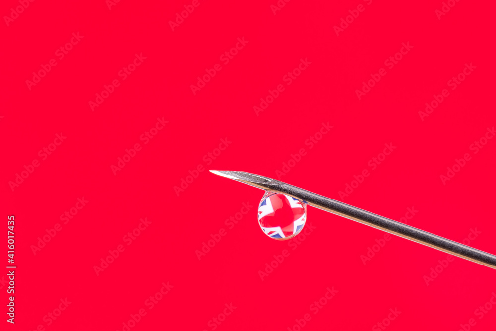 Reflection of the flag of Great Britain in a little drop on the top of the needle. Concept of vaccination against Covid-19 virus. Reflection of the flag of Great Britain in a little drop on the top of the needle. Concept of vaccination against Covid-19 virus.