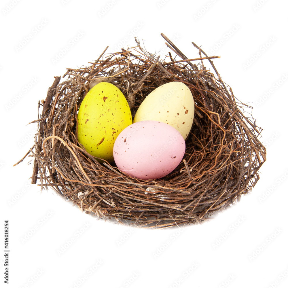 Colorful three eggs in wooden bird nest isolated on the white background
