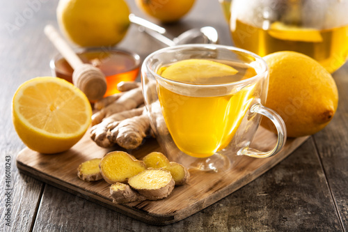 Ginger tea with lemon and honey in crystal glass on wooden table 
