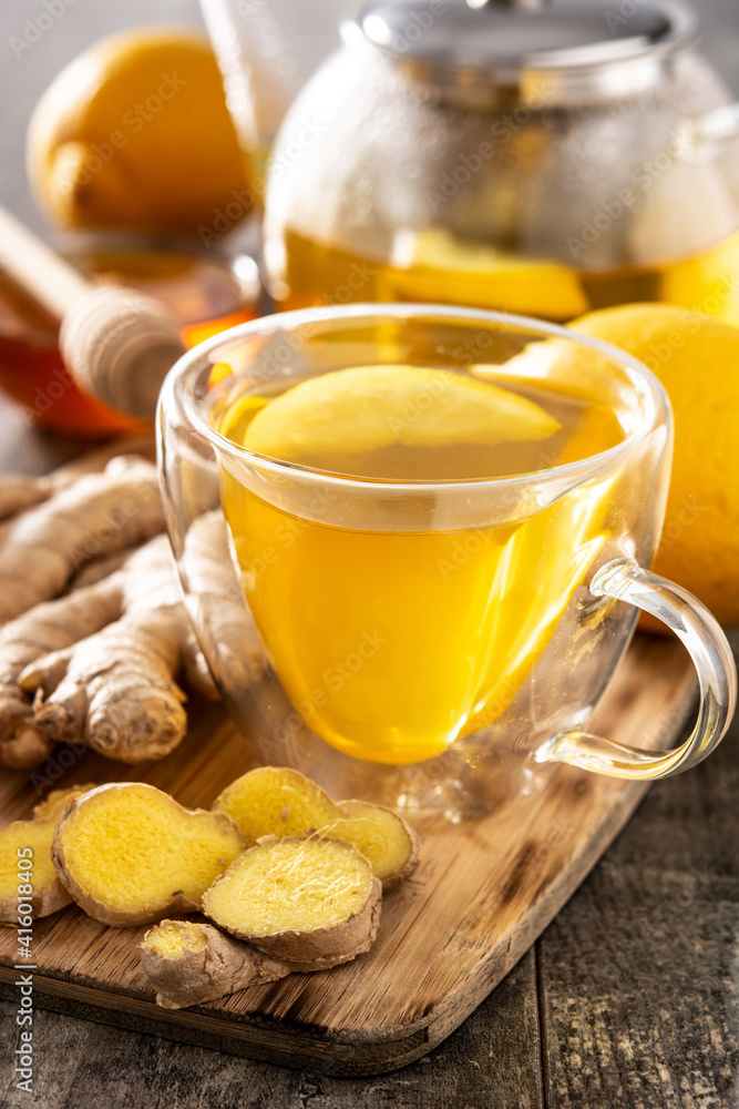 Ginger tea with lemon and honey in crystal glass on wooden table Ginger tea with lemon and honey in crystal glass on wooden table