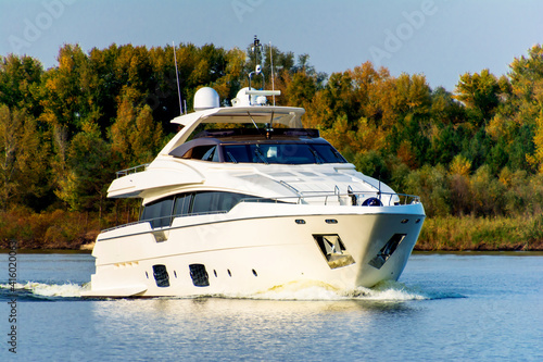 White luxury yacht in motion on the Dniepr River, side view.