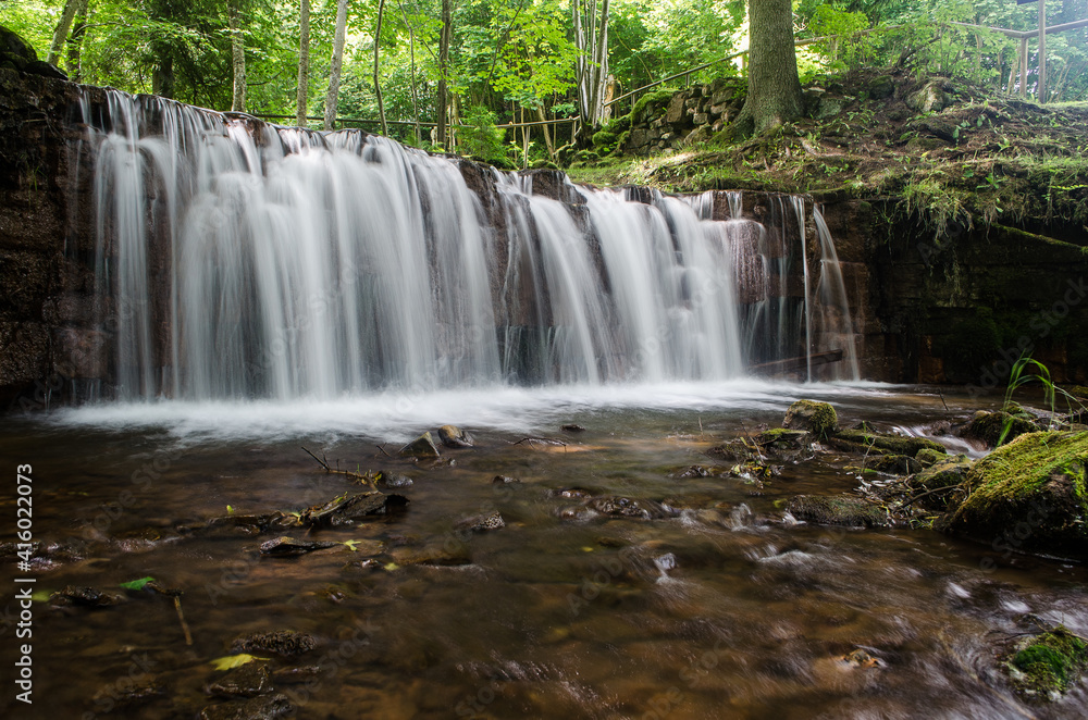 Obraz premium Long exposure Ierikupite waterfall flowing over the rock cascade, Ieriki, Latvia.