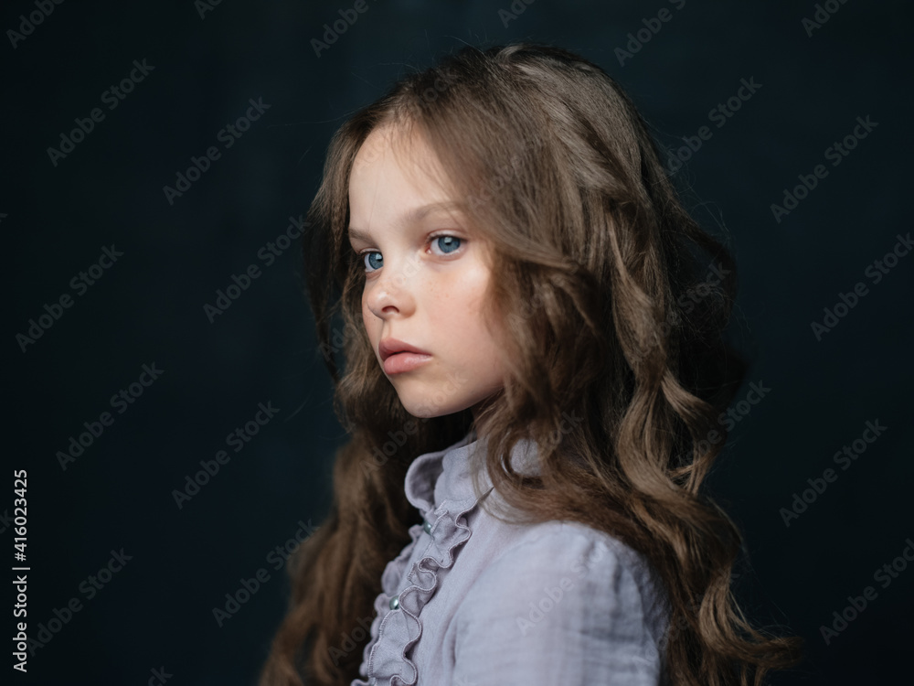 Portrait of a girl with blue eyes on a dark gray sundress background and cropped view Portrait of a girl with blue eyes on a dark gray sundress background and cropped view
