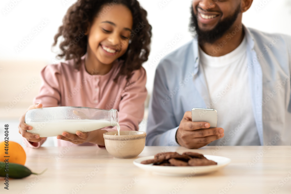 Afro Girl And Her Dad Pouring Milk In Cereal Afro Girl And Her Dad Pouring Milk In Cereal