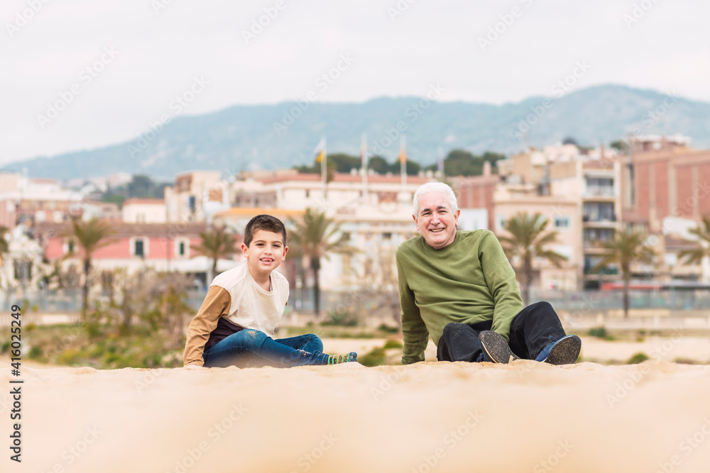 Little boy and his grandfather spending time on the beach