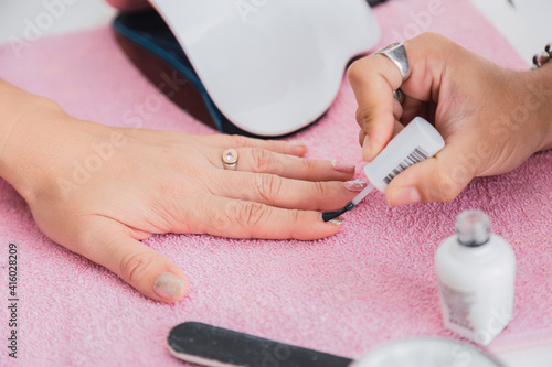 Manicure hands painting a client s nails.