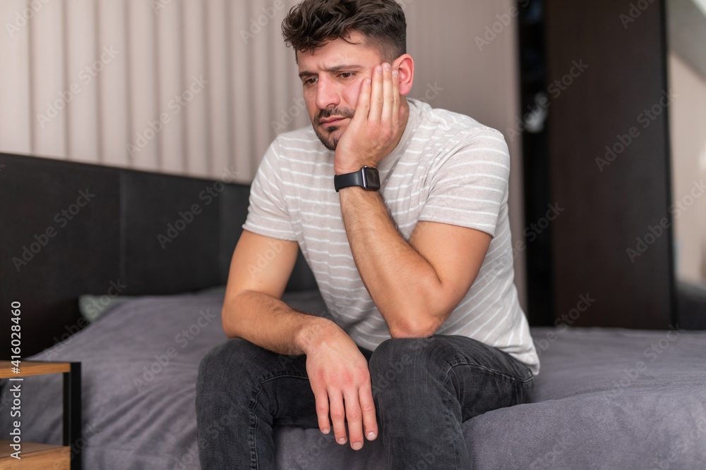Handsome Man feeling bad lying in the bed and coughing Handsome Man feeling bad lying in the bed and coughing