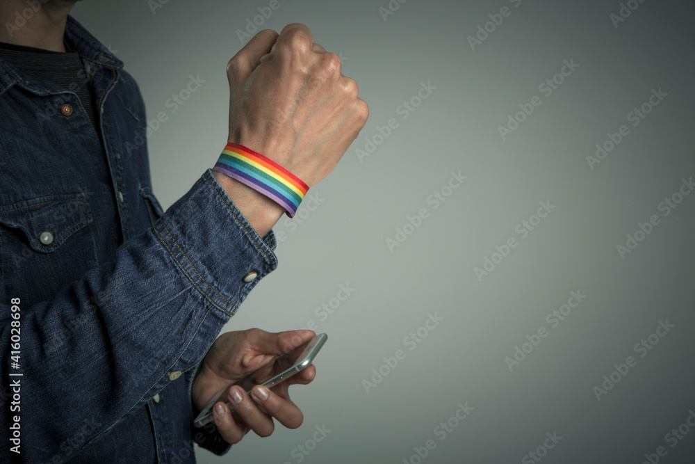 Obraz premium man hand with rainbow bracelet with clenched fist