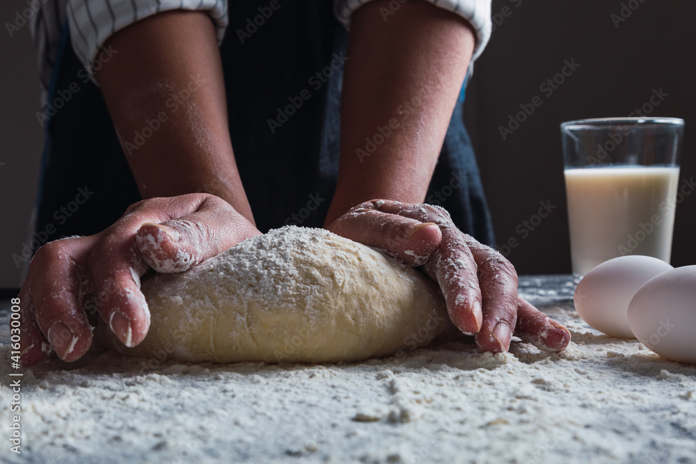 Fototapeta premium Close-up of a cook's hands kneading dough.