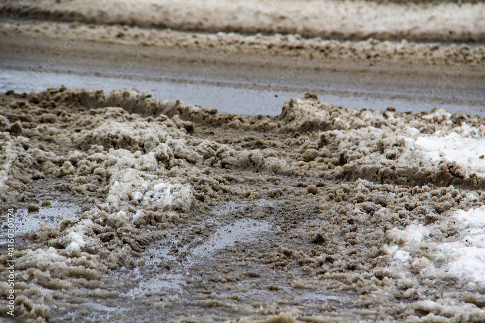 Fototapeta premium The dirty road with snow in the city Sumy in Ukraine