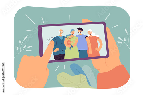 Human hands holding smartphone with family selfie isolated flat vector illustration. Cartoon photo of mom, dad, grandparents and kid making dinner in aprons. Memories and smart technologies concept