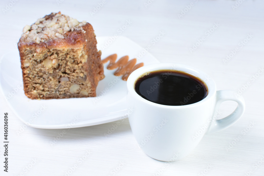 Cup of Colombian coffee, accompanied by baked cake on white wooden background Cup of Colombian coffee, accompanied by baked cake on white wooden background