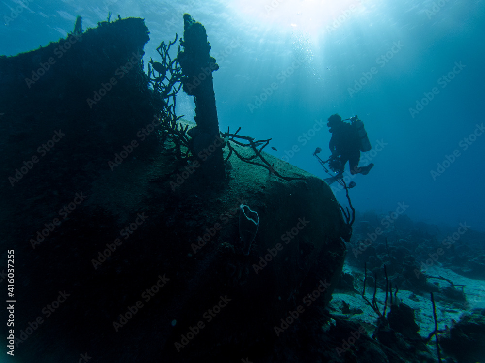 Low Angle Shot Of One Scuba Diver Photograph The Sunken Shipwreck In Caribbean Sea At Sunny Summer.