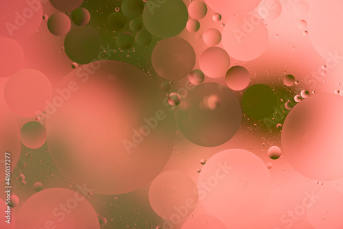 bright colorful oily drops in water with colorful background, close-up 