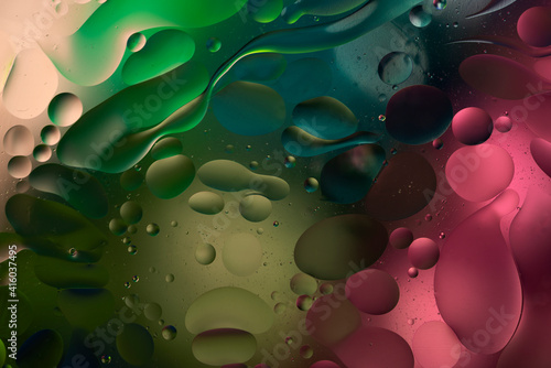 bright colorful oily drops in water with colorful background, close-up 