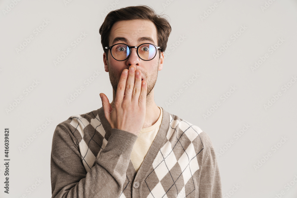 Surprised handsome guy covering his mouth and looking at camera Surprised handsome guy covering his mouth and looking at camera