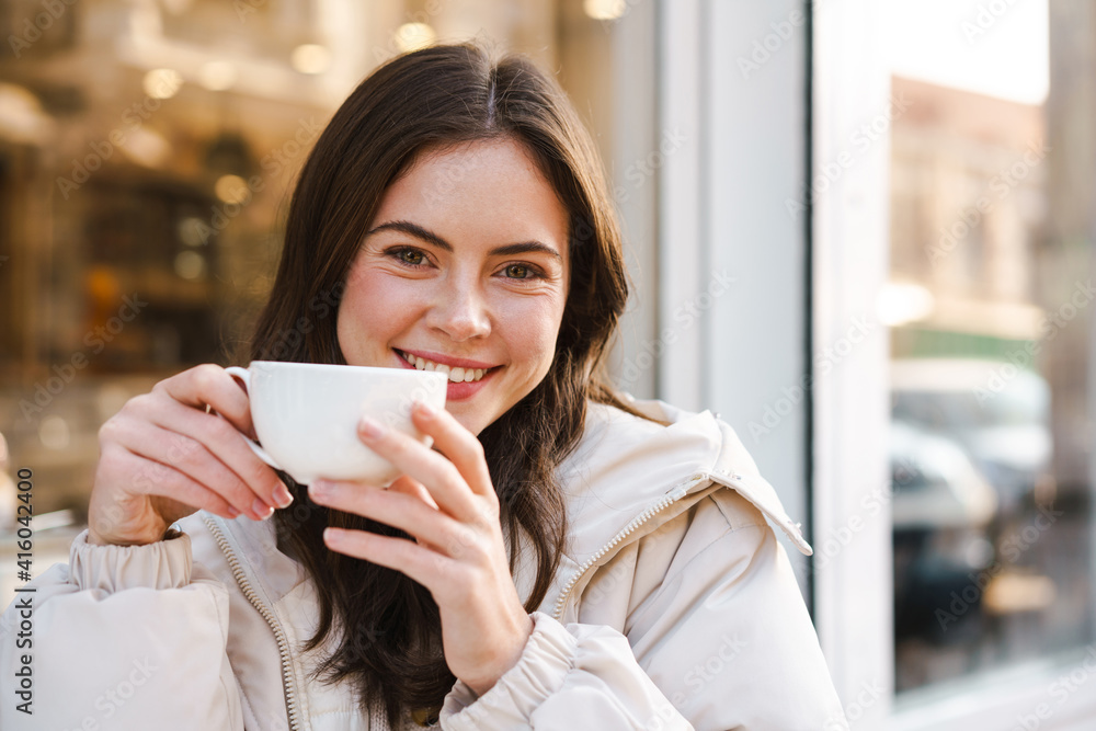 Cheerful young woman having tea with cake Cheerful young woman having tea with cake