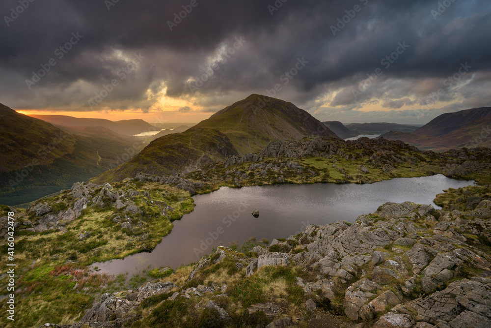 View of Haystacks Tarn overlooking Crummock Water and Ennerdale with dark forboding rain clouds in the sky. Lake District, UK.