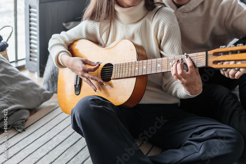 Young woman playing guitar. Close-up of woman hands playing classic guitar. teenager learning playing guitar.