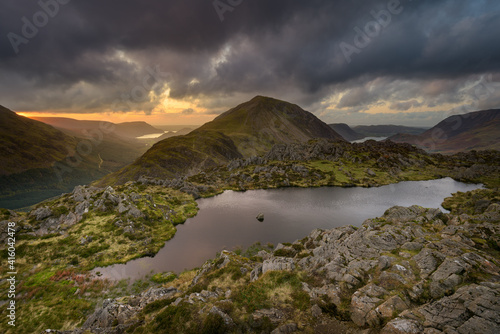 View of Haystacks Tarn overlooking Crummock Water and Ennerdale with dark forboding rain clouds in the sky. Lake District, UK.