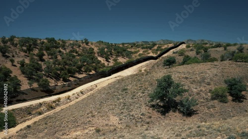 Aerial view of Nogales border area showing border fence separating the United States of America and Mexico with U.S. Border and Customs Protection patrolling border area with their vehicles